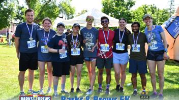 A group of people standing in line with race medals.