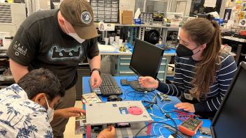 Abhay, Cordell, Kylie performing CubeSat fit check at JSC