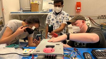 Miranda, Abhay, and Cordell performing CubeSat fit check at JSC