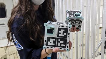 Kylie holding CubeSats